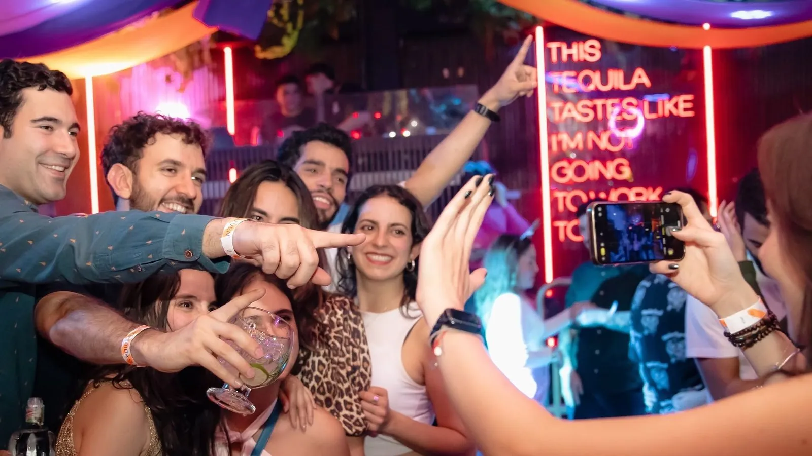 Grupo de amigos celebrando y tomándose una foto en una mesa de una discoteca aliada