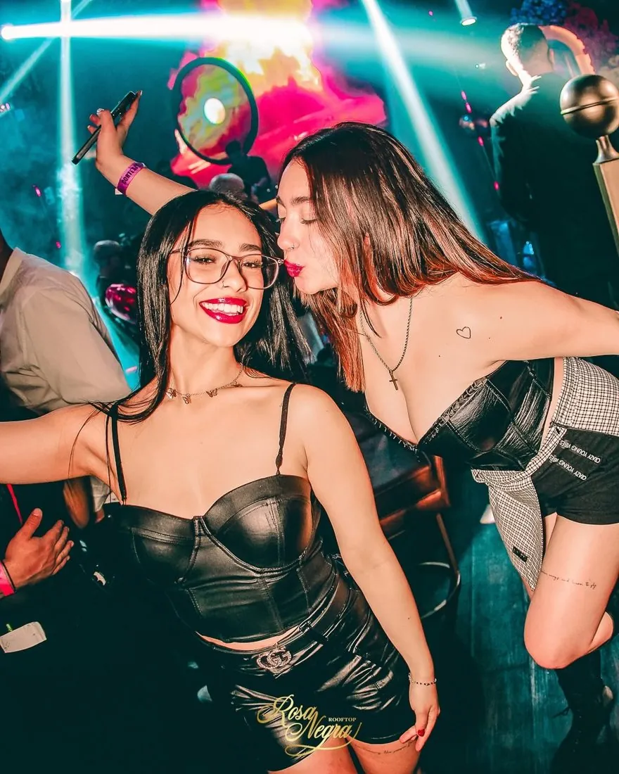 Dos amigas bailando felices en la pista de una discoteca aliada